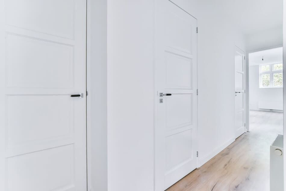 pasillo con puertas de madera lacadas en blanco